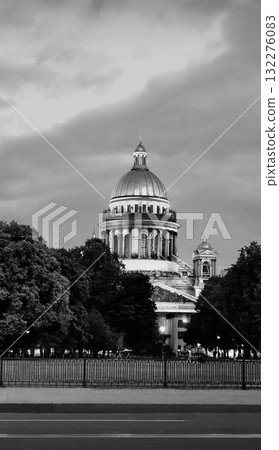 A black and white view of the majestic dome of St. Isaac's Cathedral rising above the trees in St. Petersburg. 132276083