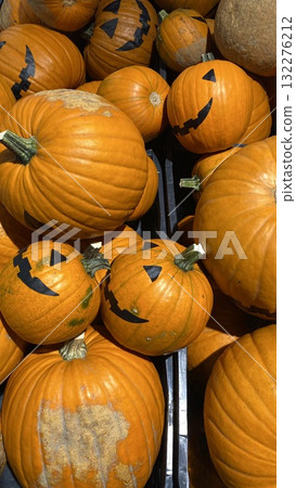 Smiling Halloween pumpkins with black faces on orange background 132276212