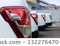 Rear lights on the tailgates of same cargo pickup trucks parked outdoors 132276470
