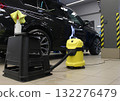 Puddles on the floor of a service station after wet cleaning the car interior with a wet vacuum cleaner 132276479