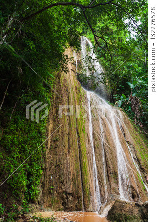 A lush jungle waterfall cascades down moss-covered rocks. Dominican Republic nature A lush jungle waterfall cascades down moss-covered rocks. Dominican Republic nature 132276578