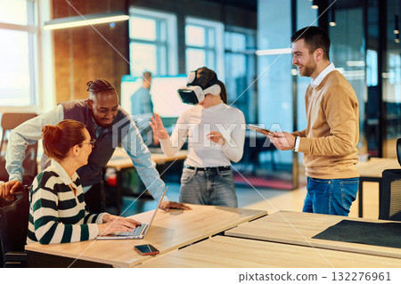 Group of creative professionals collaborating in a modern office using virtual reality headset and digital devices, representing innovation, teamwork, and futuristic workplace technology. Group of creative professionals collaborating in a modern office using virtual reality headset and digital devices, representing innovation, teamwork, and futuristic workplace technology. 132276961