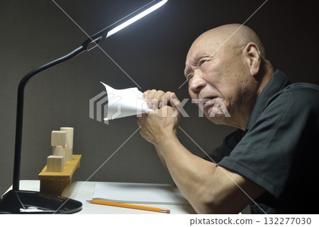 An old man regretting his actions at his desk An old man regretting his actions at his desk 132277030