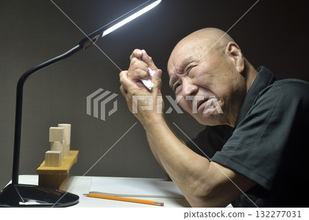 An old man regretting his actions at his desk An old man regretting his actions at his desk 132277031