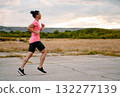 Determined Athlete Running in the Sun amidst Beautiful Nature 132277139