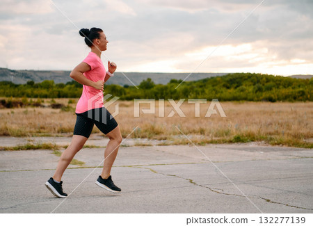 Determined Athlete Running in the Sun amidst Beautiful Nature 132277139