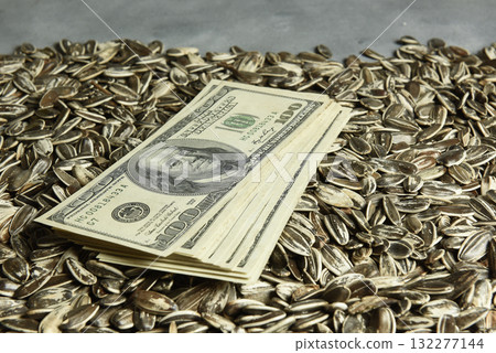 Dollars banknotes and sunflower seeds, oleaginous Commodity value concept. Dollars banknotes and sunflower seeds, oleaginous Commodity value concept. 132277144