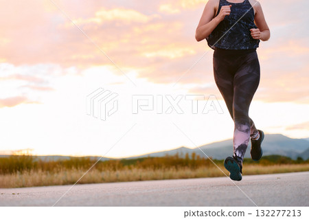 Determined Athlete Running in the Sun amidst Beautiful Nature 132277213