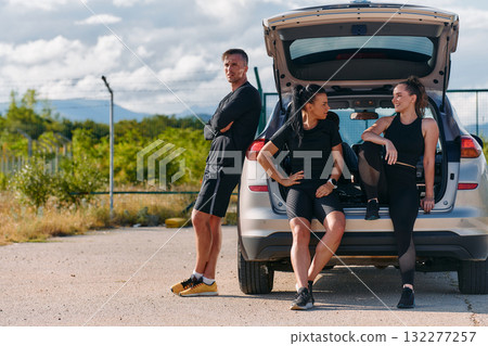Morning Prep Team of Athletes Gearing Up for Run Beside Car. Morning Prep Team of Athletes Gearing Up for Run Beside Car. 132277257