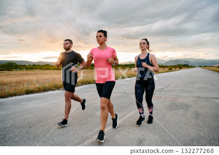 Athlete Leading Group Run at Sunset Amidst Stunning Nature 132277268