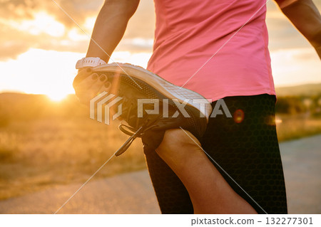 Athlete Stretching at Sunset After Intense Run 132277301