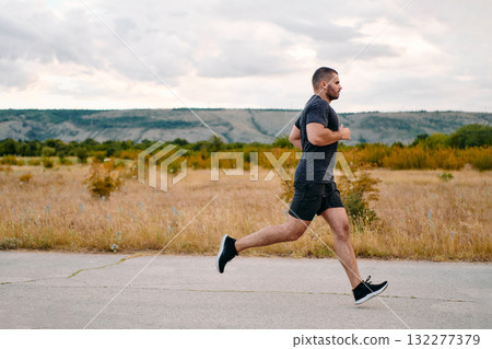 Athletic Man Jogging in the Sun, Preparing His Body for Life's Extreme Challenges Athletic Man Jogging in the Sun, Preparing His Body for Life's Extreme Challenges 132277379