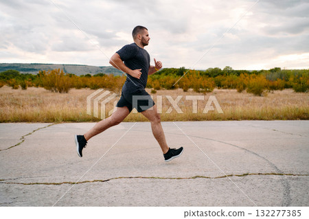 Athletic Man Jogging in the Sun, Preparing His Body for Life's Extreme Challenges Athletic Man Jogging in the Sun, Preparing His Body for Life's Extreme Challenges 132277385