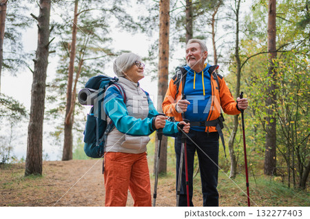 Hiking tourism adventure. Senior couple man woman enjoying outdoor recreation hiking in forest. Happy old people backpackers hikers enjoy walking hike trekking tourism active vacation beauty of nature 132277403