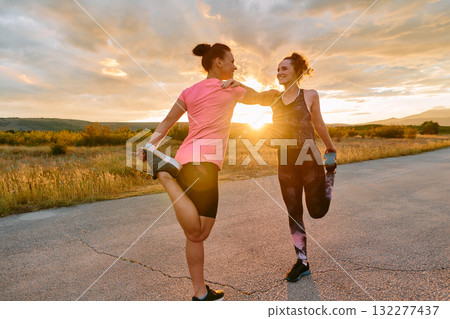 Two Women Athletes Stretching at Sunset in Beautiful Natural Surroundings 132277437