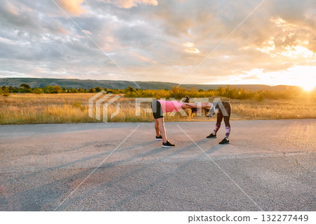 Womens Athletes Stretching at Sunset in Beautiful Natural Surroundings 132277449