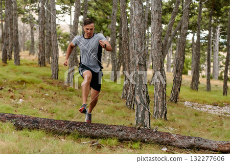 Determined Man Conquering Forest Obstacles with Grit and Speed Determined Man Conquering Forest Obstacles with Grit and Speed 132277606