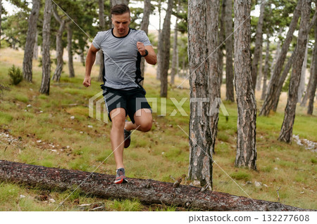 Determined Man Conquering Forest Obstacles with Grit and Speed Determined Man Conquering Forest Obstacles with Grit and Speed 132277608