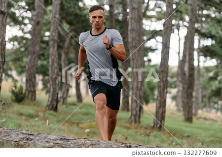 Determined Man Conquering Forest Obstacles with Grit and Speed Determined Man Conquering Forest Obstacles with Grit and Speed 132277609