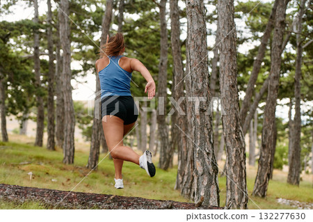 Fearless Woman Conquering Wooden Obstacles in the Dangerous Forest Terrain. 132277630