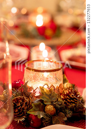 Christmas candlelight centerpiece on a red table. 132277653