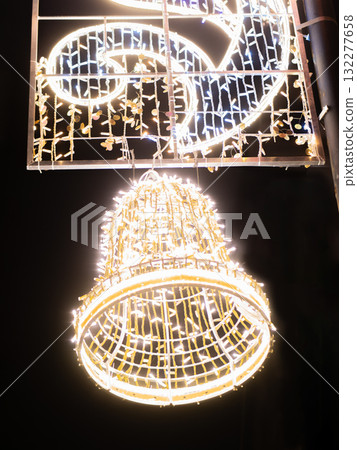 Festive bell and ornament made of bright white lights. 132277658