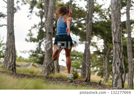 Fearless Woman Conquering Wooden Obstacles in the Dangerous Forest Terrain. Fearless Woman Conquering Wooden Obstacles in the Dangerous Forest Terrain. 132277669
