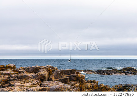 Rocky seashore. Stones covered with yellow and green moss and cloudy sky. Rocky seashore. Stones covered with yellow and green moss and cloudy sky. 132277680