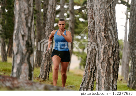 Fearless Woman Conquering Wooden Obstacles in the Dangerous Forest Terrain. 132277683