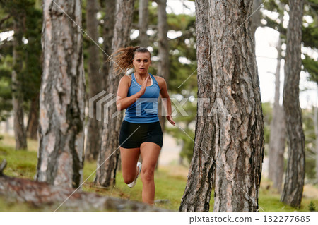 Fearless Woman Conquering Wooden Obstacles in the Dangerous Forest Terrain. 132277685