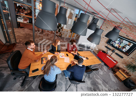 Top view of a modern startup office, a diverse team of business professionals engage in discussions on various projects and develop new business strategies, epitomizing creativity and innovation in Top view of a modern startup office, a diverse team of business professionals engage in discussions on various projects and develop new business strategies, epitomizing creativity and innovation in 132277727