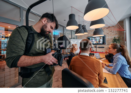 Capturing Corporate Dynamics: Videographer Films Business Meeting in Modern Office. Capturing Corporate Dynamics: Videographer Films Business Meeting in Modern Office. 132277741