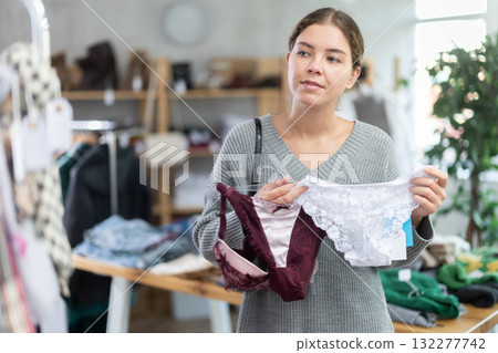 Attractive young female customer choose new panties in boutique 132277742