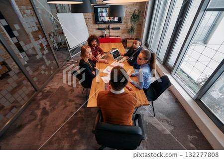 Top view of a modern startup office, a diverse team of business professionals engage in discussions on various projects and develop new business strategies, epitomizing creativity and innovation in 132277808