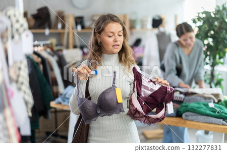 Young woman chooses underwear in clothing store Young woman chooses underwear in clothing store 132277831