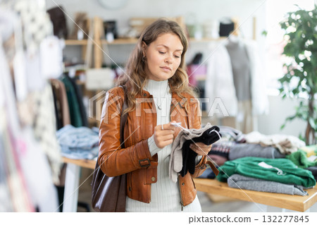 Young woman choosing gloves in clothing store Young woman choosing gloves in clothing store 132277845
