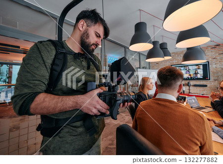 Capturing Corporate Dynamics: Videographer Films Business Meeting in Modern Office. Capturing Corporate Dynamics: Videographer Films Business Meeting in Modern Office. 132277882