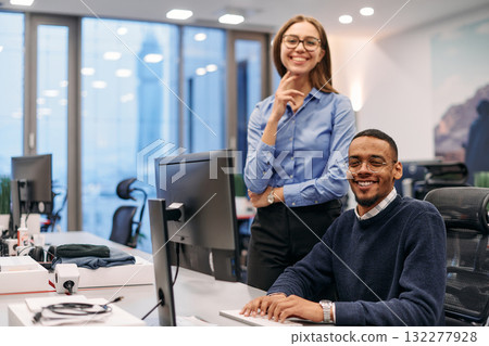 Digital Collaboration: Blonde Businesswoman and African American Partner Reviewing Documents Online 132277928