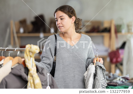 Young woman chooses outerwear in store 132277959