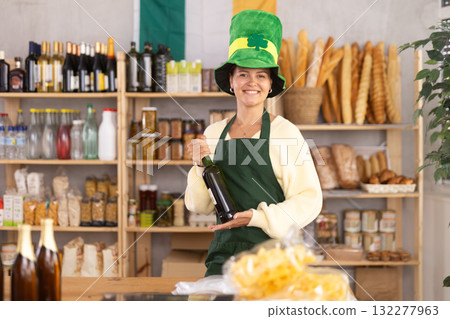 Positive female store clerk in green hat is preparing to meet customers on eve of St. Patricks Day Positive female store clerk in green hat is preparing to meet customers on eve of St. Patricks Day 132277963