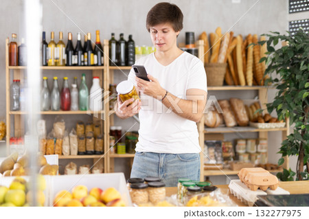 Male buyer scan pickled olives label in store Male buyer scan pickled olives label in store 132277975