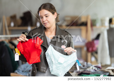 Female shopper selects panties in fashionable clothing boutique. Female shopper selects panties in fashionable clothing boutique. 132277992