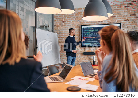 African-American businessman leads a meeting, passionately presenting a business plan to his attentive team, fostering collaboration and strategic thinking 132278010