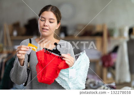 Uncertain young girl choosing panties in clothing store Uncertain young girl choosing panties in clothing store 132278038