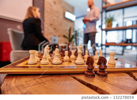 Strategic Moves: A Close Up of Chess Pieces Symbolizing Business Tactics Amidst Team Discussions. 132278059