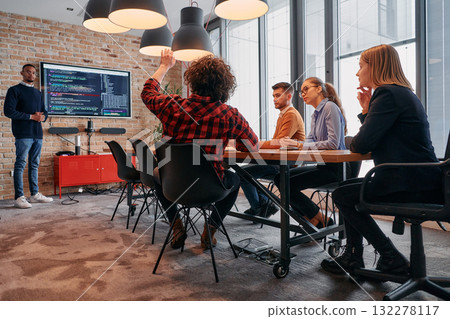 African-American businessman leads a meeting, passionately presenting a business plan to his attentive team, fostering collaboration and strategic thinking 132278117