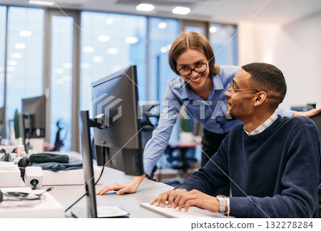Digital Collaboration: Blonde Businesswoman and African American Partner Reviewing Documents Online 132278284