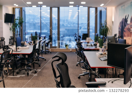 Front view of coworking office interior with workplaces, blank picture frame on wall and computer.  132278293