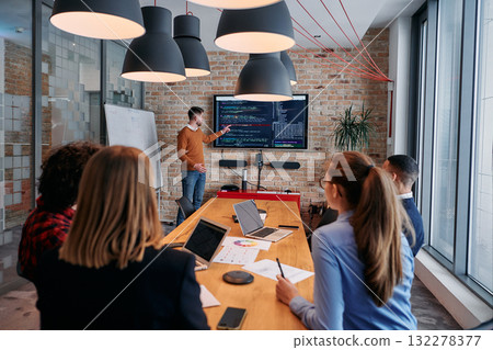 In a corporate setting businessman leads a meeting, passionately presenting a business plan to his attentive team, fostering collaboration and strategic thinking In a corporate setting businessman leads a meeting, passionately presenting a business plan to his attentive team, fostering collaboration and strategic thinking 132278377
