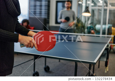 Business colleagues take a break from work to enjoy a game of table tennis, fostering teamwork and camaraderie in the workplace Business colleagues take a break from work to enjoy a game of table tennis, fostering teamwork and camaraderie in the workplace 132278434